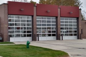 Three glass and aluminum garage door systems on a commercial building.