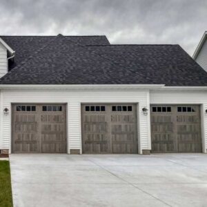 three brown residential garage doors on a modern home